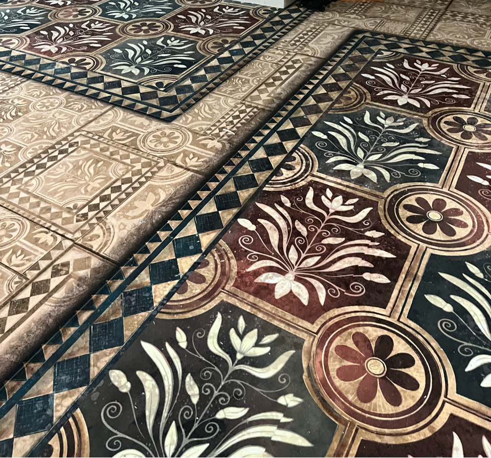 Dekorativer individuell bedruckter PVC-Boden zeigt florale Muster und geometrische Formen in verschiedenen Farben auf quadratischen Fliesen. Die kräftigen Farben betonen das Design und die abwechslungsreichen Muster.